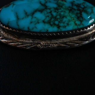 Reserved Grace vintage Navajo sterling silver pin featuring a large oval turquoise cabochon with dark matrix patterns.