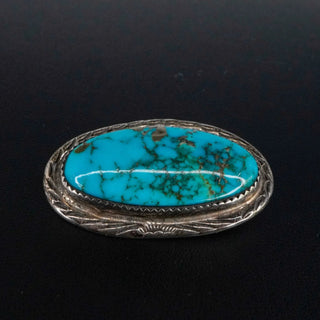 Reserved Grace vintage Navajo sterling silver pin featuring an oval turquoise cabochon with dark matrix patterns.