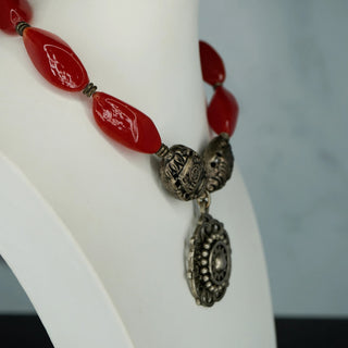 Reserved Grace artisan necklace featuring red carnelian beads and a detailed sterling silver medallion pendant.