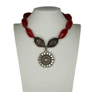 Reserved Grace artisan necklace featuring red carnelian beads and a sterling silver medallion pendant on a display bust.