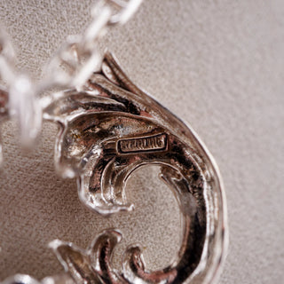 Reserved Grace vintage sterling silver Rococo key pendant featuring a detailed stamped hallmark on a textured surface
