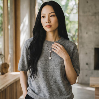 Reserved Grace sterling silver spoon pendant necklace worn by a woman in a grey knit top in a modern interior