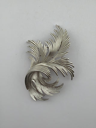 Reserved Grace vintage Trifari silver-tone brooch featuring an elegant brushed metal leaf and feather design.