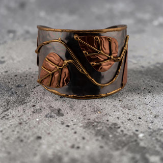 Reserved Grace Anju tri-tone cuff bracelet featuring silver, copper, and brass leaf appliqués on a wide metal band.