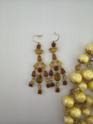 Reserved Grace vintage-inspired chandelier earrings with amber stones and faux pearl necklace on white background