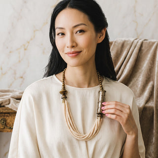 Reserved Grace vintage multi-strand cream beaded necklace with textured brass accents worn by a woman
