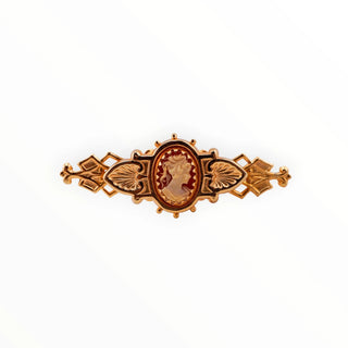 Reserved Grace vintage goldtone bar pin featuring an elegant resin cameo with intricate filigree metalwork.