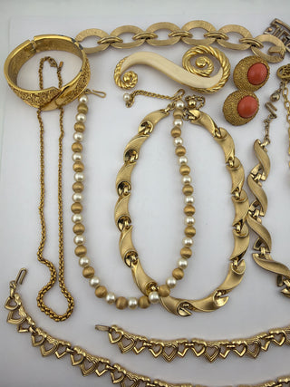 Reserved Grace vintage gold-tone jewelry collection featuring pearl necklaces, heart-link chains, and coral-tone earrings.