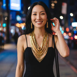 Reserved Grace vintage Whiting & Davis gold mesh necklace and tassel clip earrings worn by a woman in a black dress