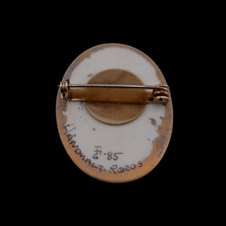 Reserved Grace vintage 1985 hand-painted Norwegian ceramic brooch back view with artist signature and pin mechanism