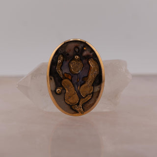 Reserved Grace vintage 1985 hand-painted Norwegian ceramic brooch with abstract gold luster glaze on a grey background.