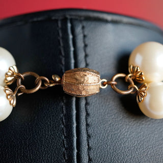 Reserved Grace vintage necklace featuring a textured gold-tone barrel clasp connecting two strands of lustrous faux pearls.
