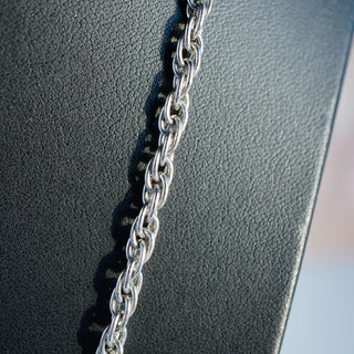 Reserved Grace vintage Crown Trifari silver tone chain necklace with textured oval links on a black display stand