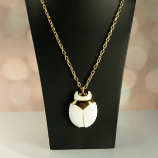 Reserved Grace vintage Crown Trifari beetle pendant necklace featuring a white lucite body and gold-tone metal frame.