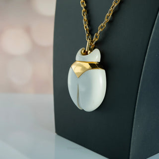 Reserved Grace vintage Crown Trifari beetle pendant necklace featuring a white lucite body and gold-tone metal frame.