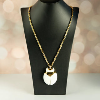 Reserved Grace vintage Crown Trifari beetle pendant necklace with white lucite and gold-tone metal on a display bust.