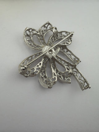 Reserved Grace vintage Trifari silver-tone filigree bow brooch showing the secure pin back and maker mark