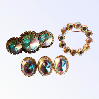 Set of vintage brooches with multicolored gemstones on a light purple background